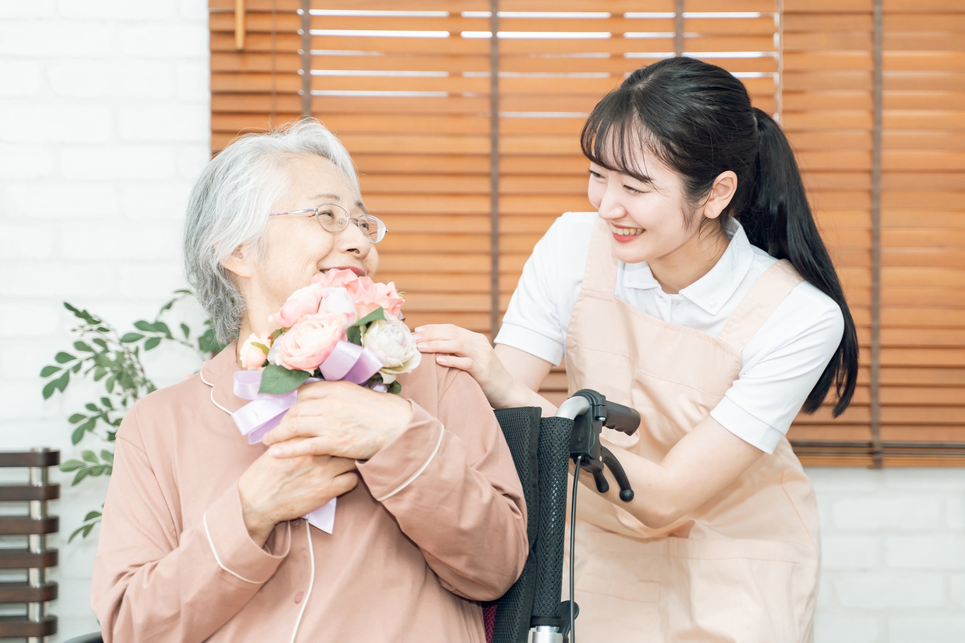 介護職員が高齢者に花束を贈呈する温かい交流シーン